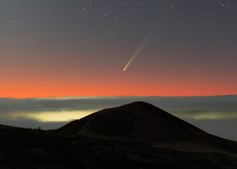 Mountain with cloud bank and pink sky above plus comet.