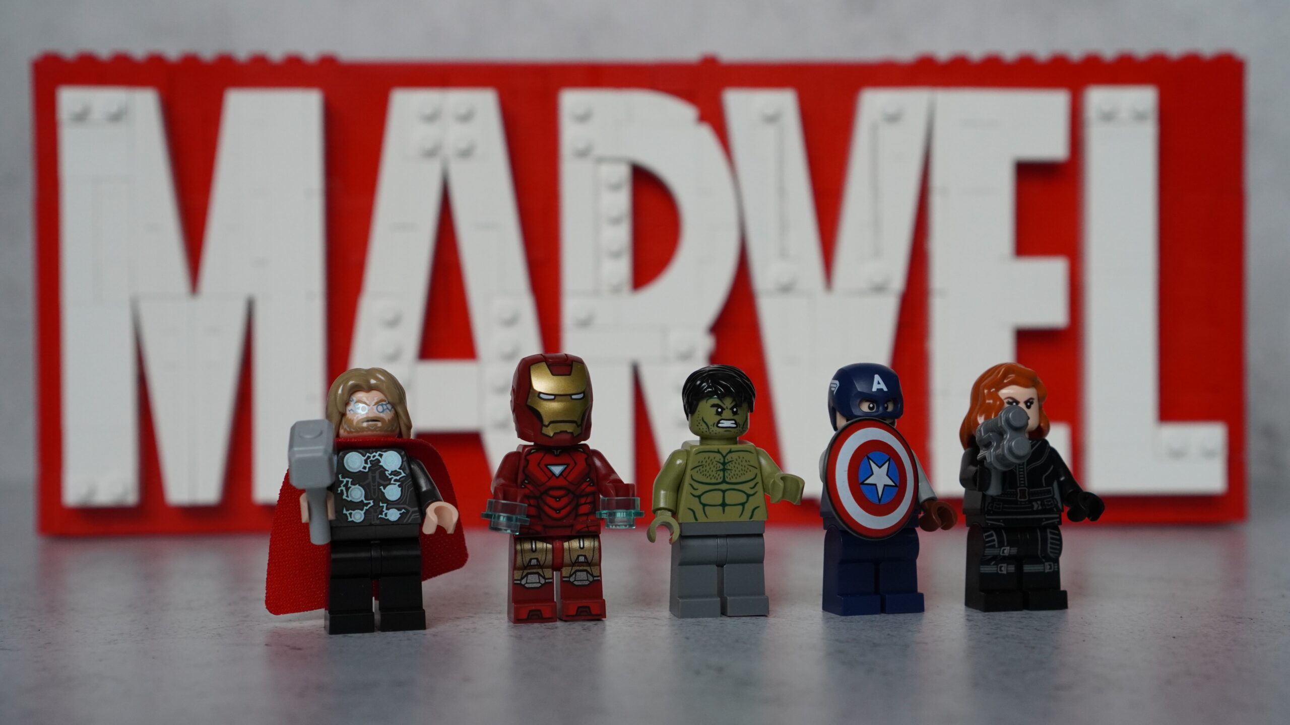 Lego Marvel Logo & Minifigures set with the minifigures stood in front