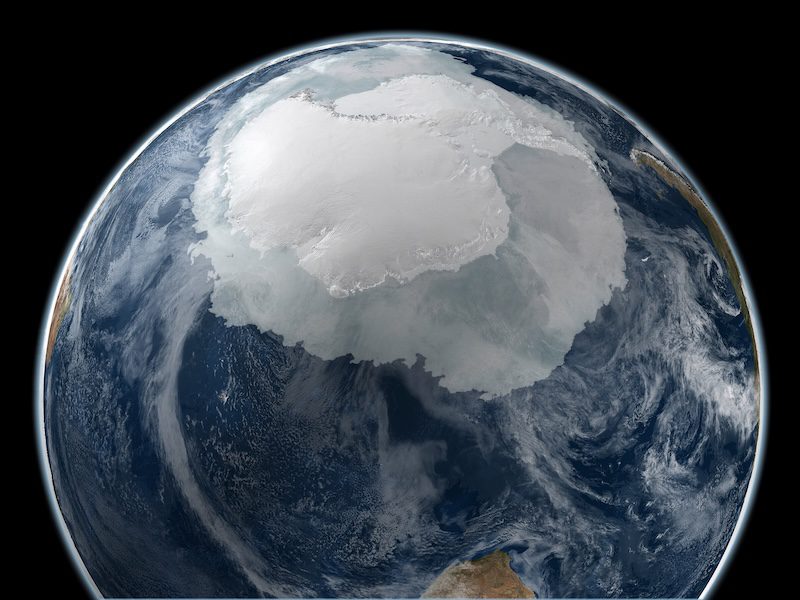 Earth's ice caps: About 3/4 of Earth with a large part of the upper region covered in white ice. Ocean and clouds surround the ice area.