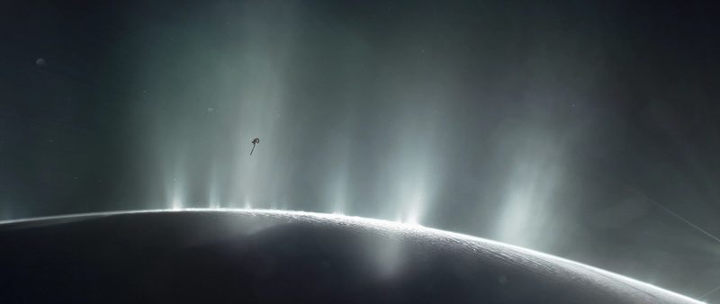 Life on Enceladus: Shadowed edge of planet-like body with several bright plumes erupting from the surface. Small spacecraft close to the plumes.