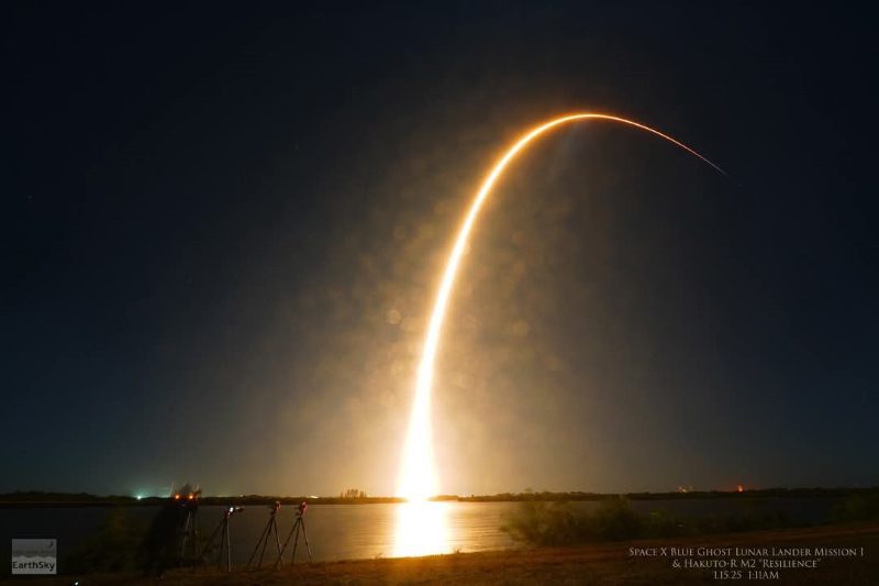 Against a night sky, a blazingly bright white and orange line shoots up from the horizon and curves to the right.