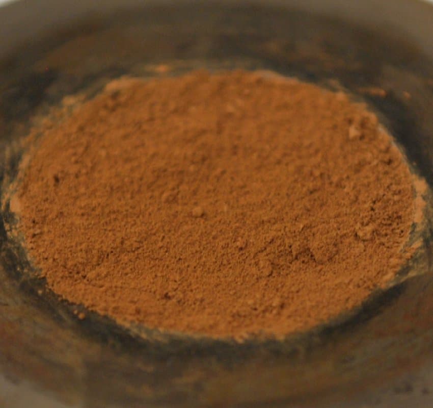 A disc of orange-terracotta coloured dust fills the frame. The dust looks quite soft and fine, more like flour than sand