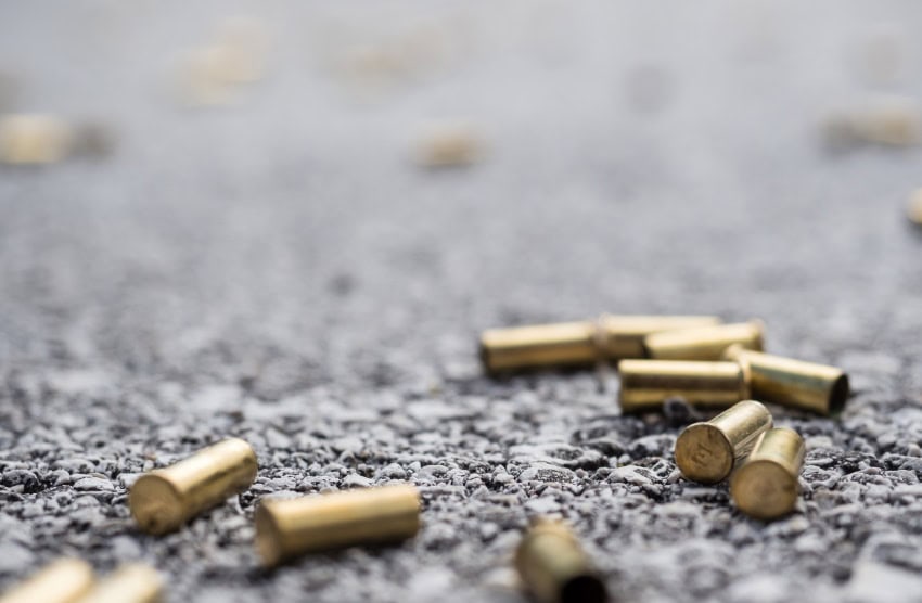 Numerous bullet casings lying on asphalt