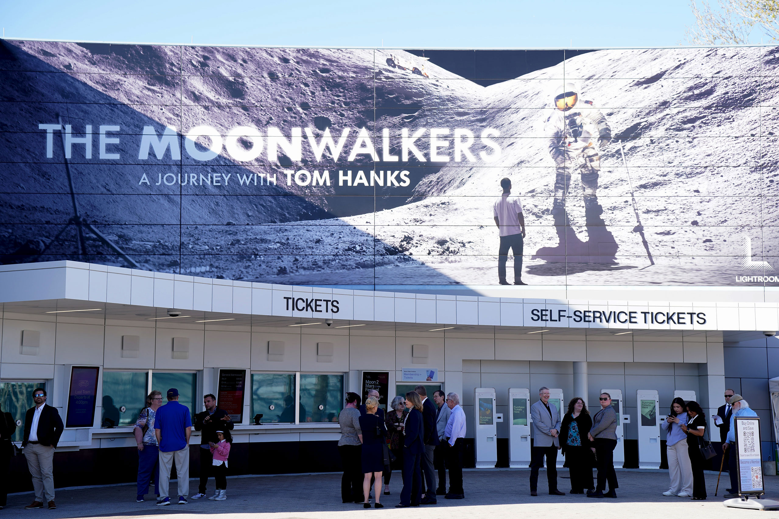 a large mural of an Cosmos traveler on the Orbiter is seen above the ticket counter at the entrance to a museum