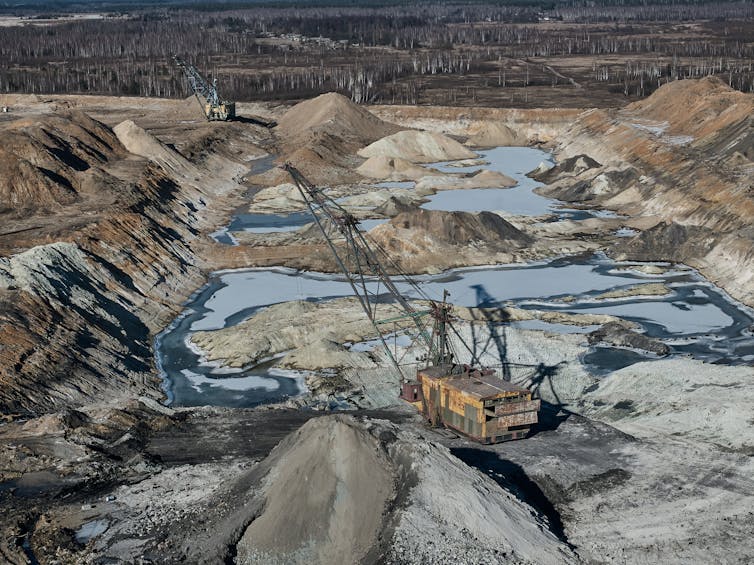 Excavators work in a vast mined area.