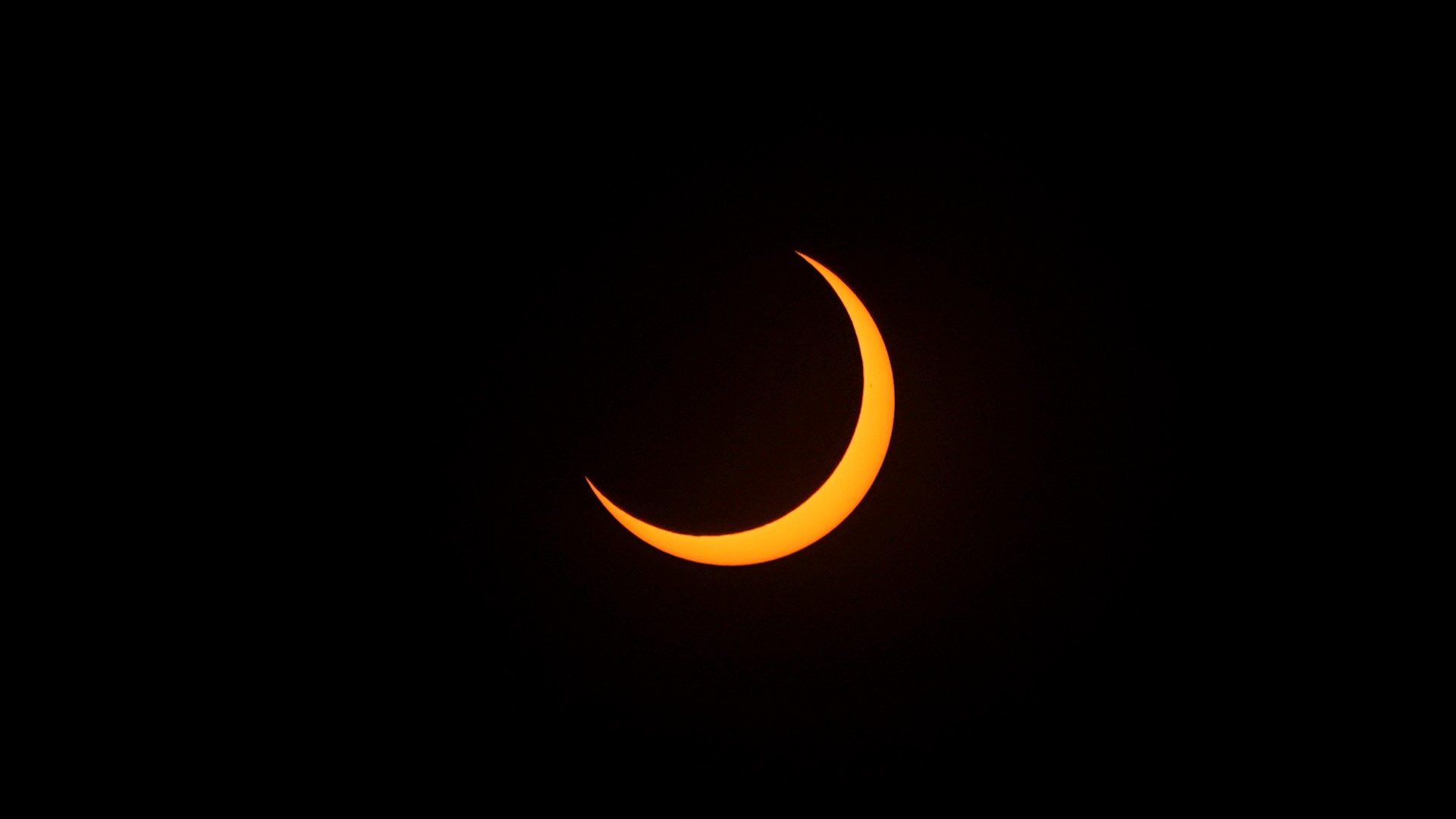 the sun appears as a Clever crescent on a black background