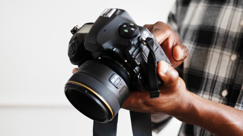 A person holding a DSLR camera